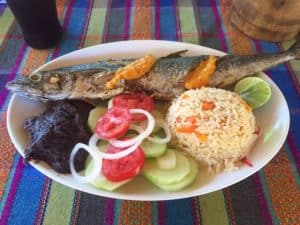 oval plate with whole fish, beans, rice