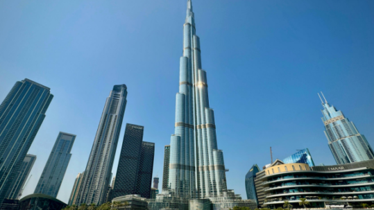 Burj Khalifa skyscraper in downtown Dubai surrounded by luxury towers and waterfront architecture on a sunny day