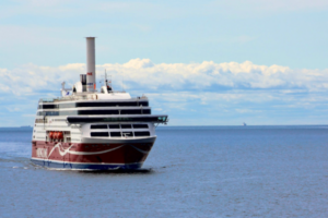 Passenger ferry sailing across calm blue ocean under a partly cloudy sky