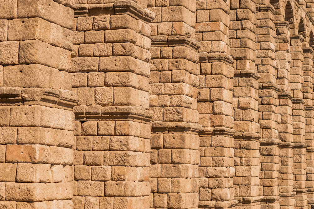 Close-up of ancient stone columns and textured masonry wall built from stacked rectangular blocks